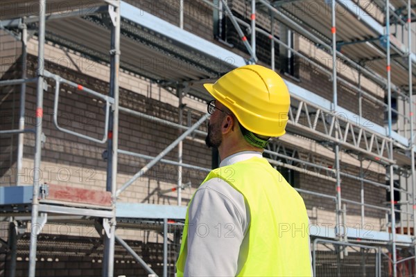 Symbolic image: Architect in front of an apartment block under construction