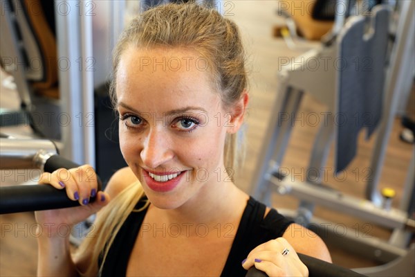 Young woman training on equipment in the gym