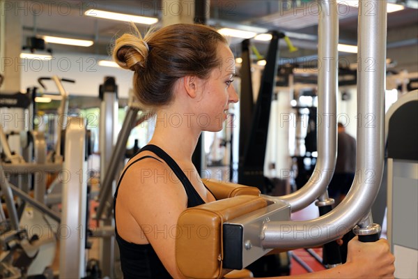 Young woman training on equipment in the gym