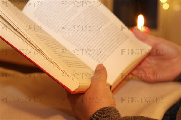 Woman comfortably reading a book on the sofa