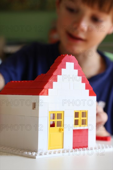 Symbolic image: Boy builds a house with building blocks