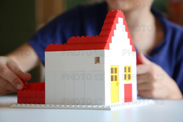 Symbolic image: Boy builds a house with building blocks