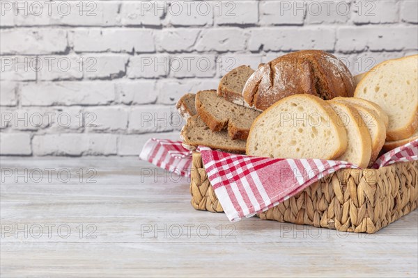 A basket with different types of bread on a brick wall, copy room