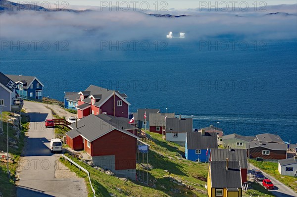 Colourful houses in front of a foggy fjord with icebergs, Qaqortoq, Greenland, Denmark, North America