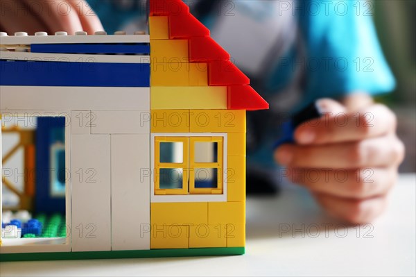 Boy builds a house with building blocks