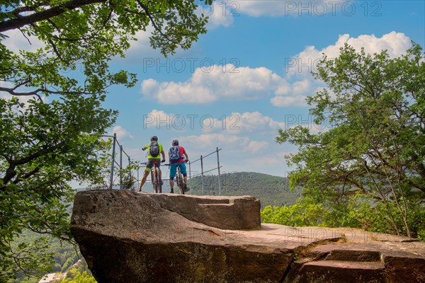 Mountain bikers take a break at a viewpoint above Wolfsburg Castle in the Palatinate Forest, Germany, Europe