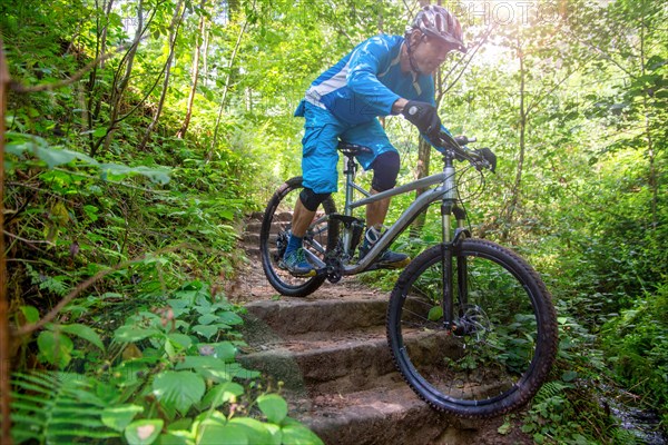 Mountain biker riding steps on a single trail in the Palatinate Forest, Germany, Europe