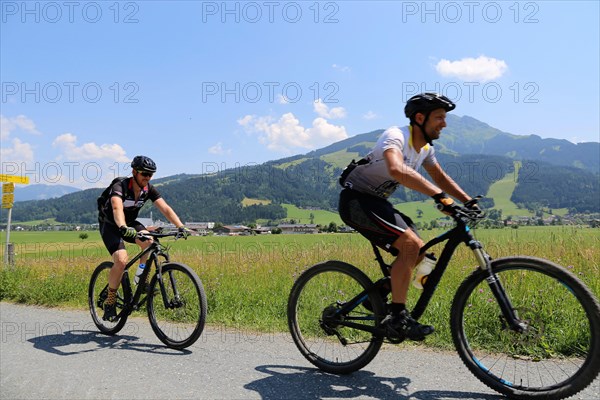 Mountain bikers in the Kitzbuehel Alps with alternating views of the Wilder Kaiser and the Kitzbueheler Horn