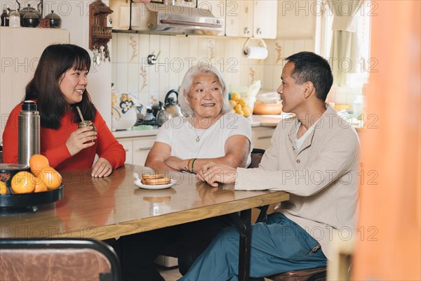 Japanese Family talking and drinking yerba mate at home. Argentinian family of Japanese descent sharing mate at home