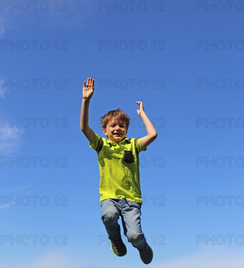 Symbolic image: Boy jumping into the air, blue sky in the background