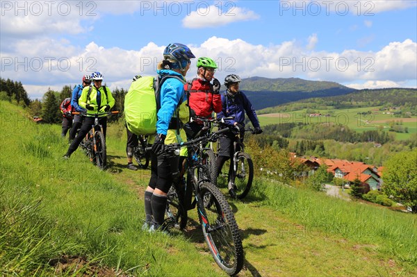 Participants of the Trans Bayerwald from the DAV Summit Club take a short break. In the background you can see the Osser, which marks the border between the Bavarian Forest and the Bohemian Forest