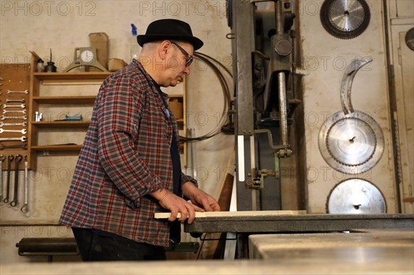 Furniture restorer works with a jigsaw