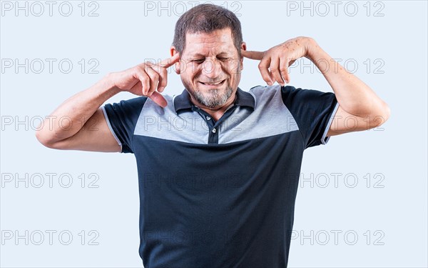 Displeased senior man covering his ears isolated. Older people ignoring and covering ears
