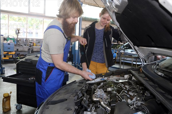 Symbolic image: Car mechatronics technician with customer in the garage