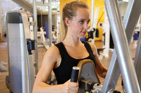 Young woman training on equipment in the gym