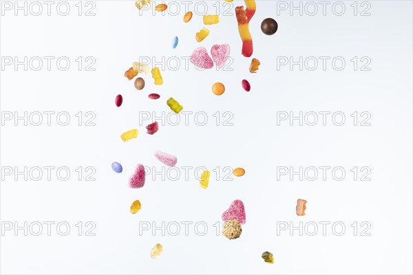 Colourful sweets fall against a white background