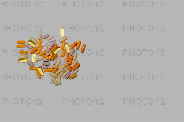 Flat lay of assortment of vitamin supplements on grayish white background