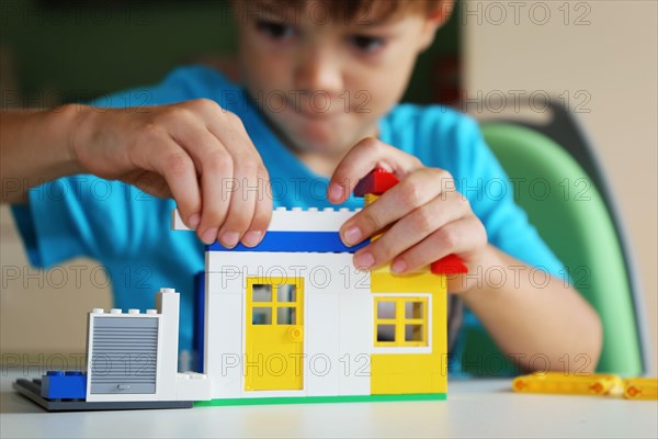 Boy builds a house with building blocks