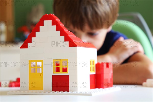 Boy builds a house with building blocks