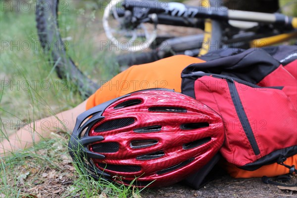 Injured mountain biker lying on the ground in an accident