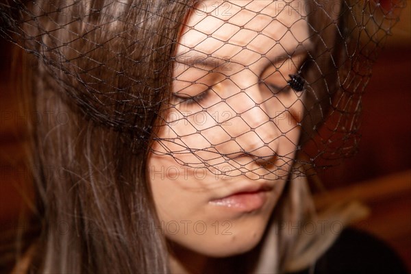 Close-up of a grieving young woman with a mourning veil in church (symbolic image)