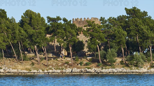 Old stone castle surrounded by pine trees on the Mediterranean coast, Gythio, Mani, Peloponnese, Greece, Europe