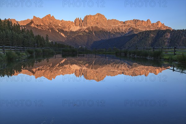 Mountains reflected in a small mountain lake, sunset, evening light, Wuhnleger, view of rose garden, Dolomites, South Tyrol, Italy, Europe