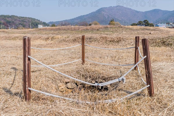 Water well cordoned off with wooden beams and rope at remains of stone fortress in Yeosu, South Korea, Asia