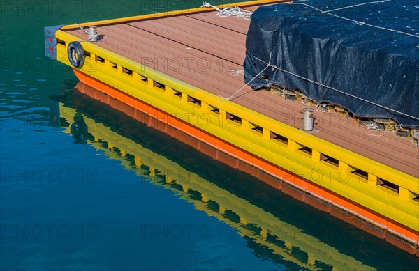 Round lobster traps under black mesh stacked on floating dock at ocean port in South Korea