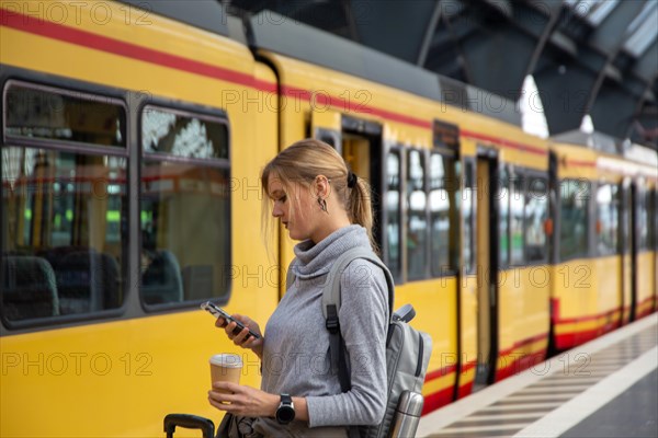 Close-up of a young woman in front of a train at the station