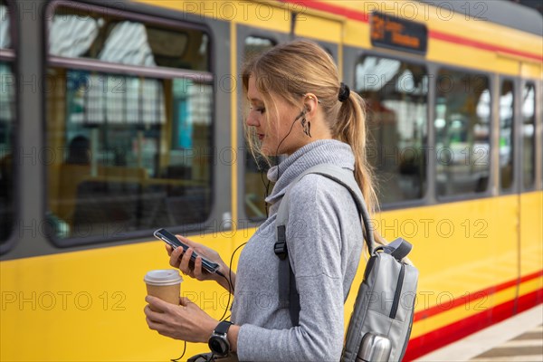 Close-up of a young woman in front of a train at the station