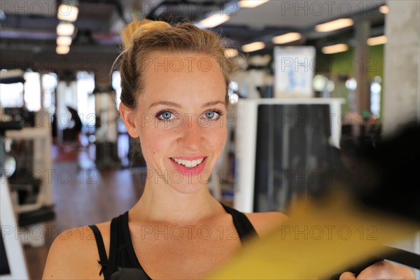 Young woman doing TRX training in the gym, (Neuhofen, Rhineland-Palatinate)