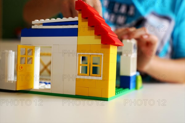 Boy builds a house with building blocks