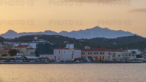 Coastline with buildings and mountains during a colourful sunset, Snow-covered Taygetos Mountains, Taygetos, Gythio, Mani, Peloponnese, Greece, Europe