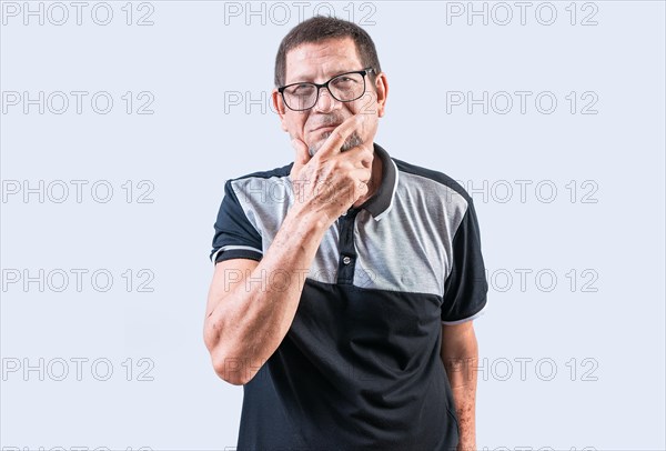 Pensive senior man with hand on chin meditating isolated. Senior people thinking with hand on chin looking at camera