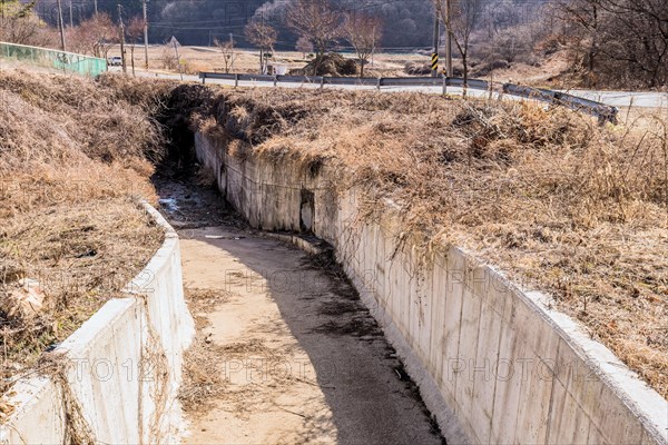 Concrete spillway in rural countryside beside country road