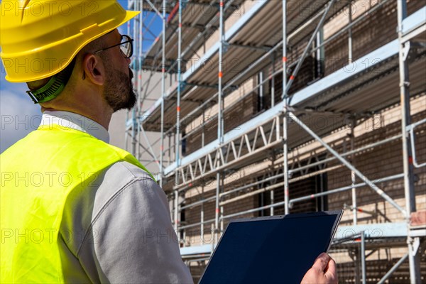 Symbolic image: Architect in front of an apartment block under construction