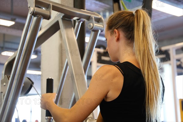 Young woman training on equipment in the gym