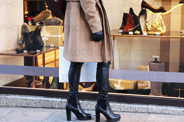 Symbolic image: Elegant young woman standing in front of a shoe shop