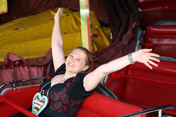 Cheerful woman travelling up and down the mountain at the Brezelfest in Speyer, Rhineland-Palatinate