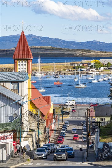Yellow-red church in a steep street, boats in the harbour at the Beagle Channel, Ushuaia, Tierra del Fuego Island, Patagonia, Argentina, South America