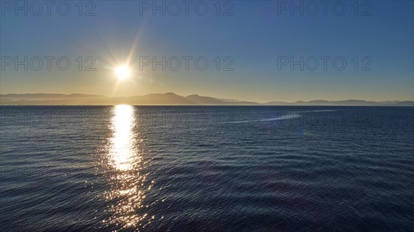 Sunrise over the sea with calm waves and clear sky, Gythio, Mani, Peloponnese, Greece, Europe