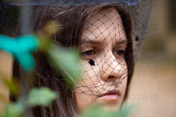 Close-up of a grieving young woman with a mourning veil (symbolic image)