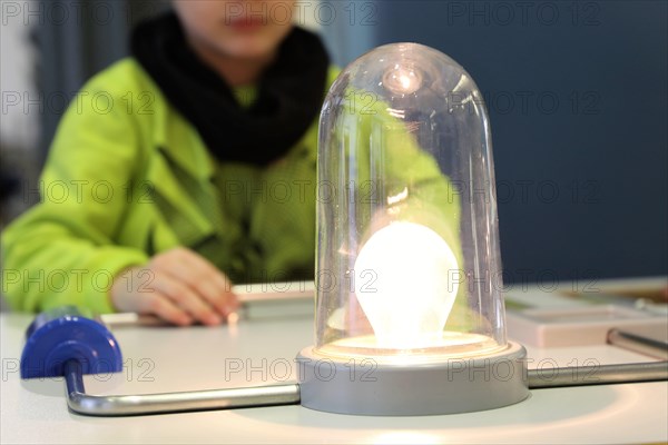 Child conducting a physics experiment with a simple circuit