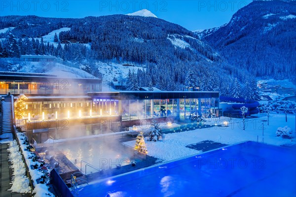 Snow-covered rock spa in winter, thermal bath with Christmas lights at dusk, Bad Gastein, Gastein Valley, Hohe Tauern National Park, Salzburg Province, Austria, Europe