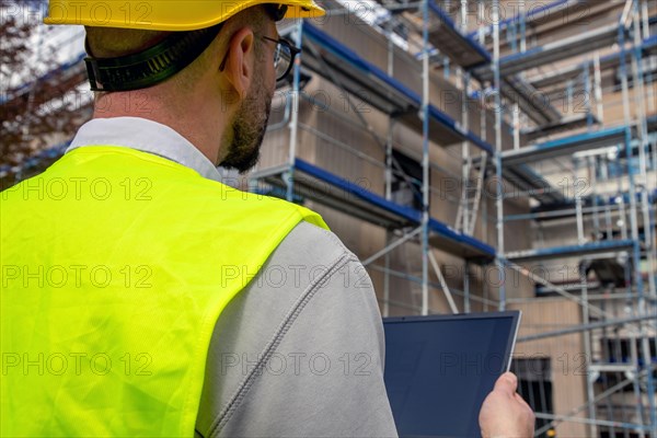 Symbolic image: Architect in front of an apartment block under construction