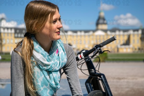 Young woman with bicycle enjoying the spring weather in Karlsruhe Palace Gardens (symbolic image)