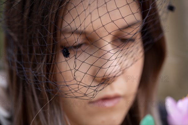 Close-up of a grieving young woman with a mourning veil (symbolic image)