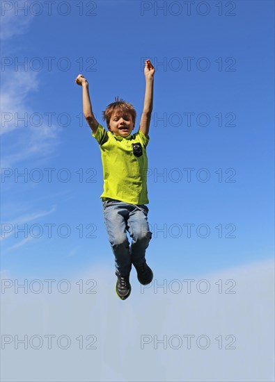 Symbolic image: Boy jumping into the air, blue sky in the background