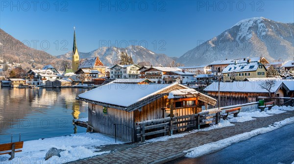Snowy winter view of Malerwinkel with boathouses, parish church and Wallberg 1722m, Rottach-Egern, Tegernsee, Tegernsee valley, Bavarian Alps, Upper Bavaria, Bavaria, Germany, Europe
